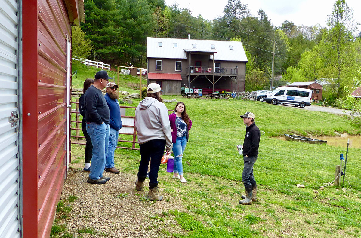 Tourgoers listen to farm hands